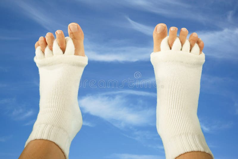 Feet with Yoga Toe Separator Socks on Sky Background Stock Image