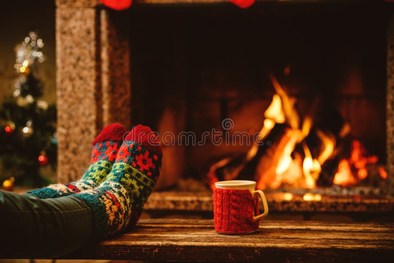 Füße in Wollsocken zu Weihnachten Kamin.