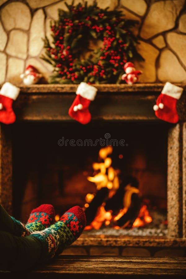 Feet in woollen socks by the fireplace. Woman relaxes by warm fi stock image Feet in woollen socks by the fireplace. Woman relaxes by warm fi stock image