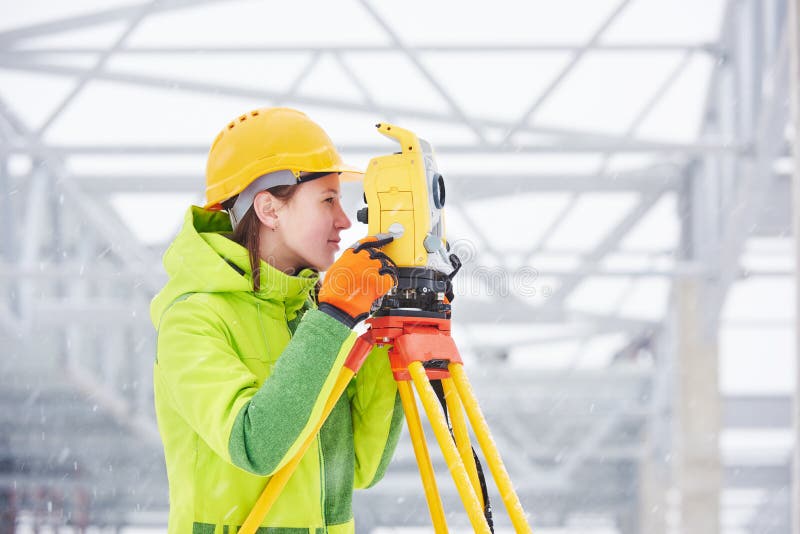 Female surveyor worker working with theodolite transit equipment at road construction site outdoors. Female surveyor worker working with theodolite transit equipment at road construction site outdoors