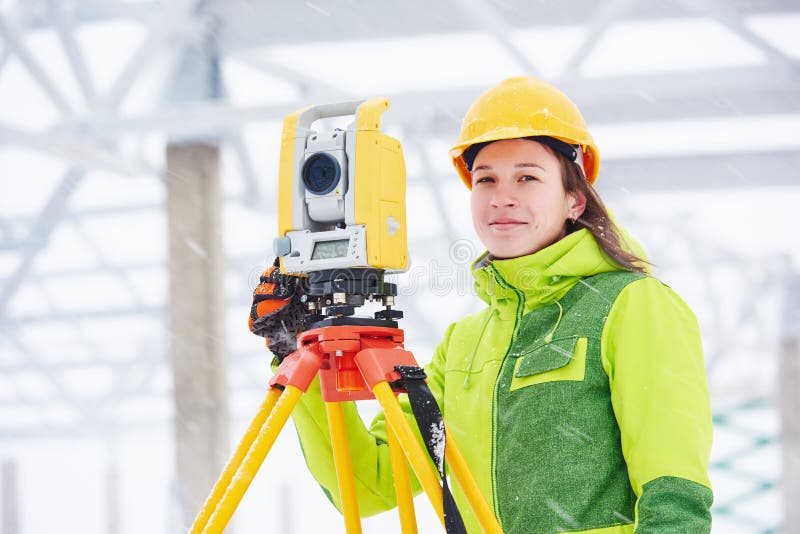 Female surveyor worker working with theodolite transit equipment at building construction site outdoors. Female surveyor worker working with theodolite transit equipment at building construction site outdoors