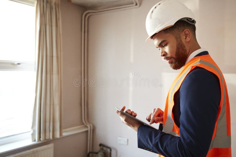 Feldmesser In Hard Hat und hohe Sicht-Jacke mit Digital-Tablet-Durchführungshaus-Inspektion stockbild Feldmesser In Hard Hat und hohe Sicht-Jacke mit Digital-Tablet-Durchführungshaus-Inspektion stockbild