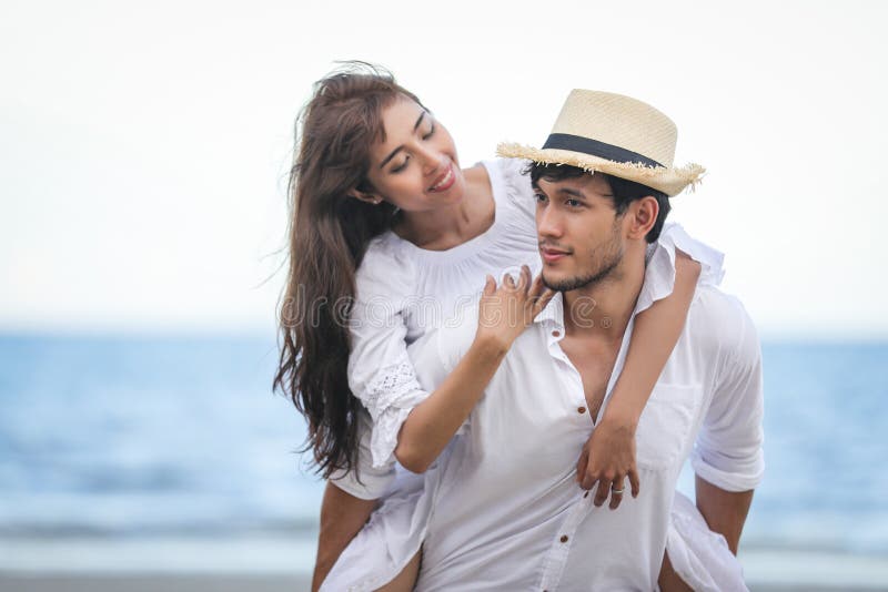 Felice amante romantica delle coppie che si tengono per mano camminando sulla spiaggia fotografia stock