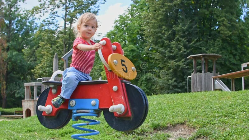 Felice bambino che si diverte a giocare con giochi colorati di legno nel parco, bella giornata di sole estiva nei bambini al parc archivi video