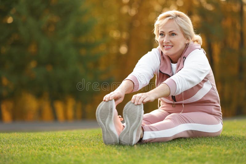 Felice donna matura che si allunga Stile di vita attivo immagini stock Felice donna matura che si allunga Stile di vita attivo immagini stock