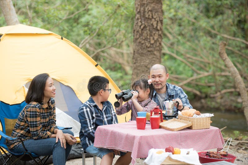 Happy family has father and mother, brother and sister asian having fun to camping in river in summer time with smile and laughing healthy. summer camp for kids. vacation lifestyle concept. Happy family has father and mother, brother and sister asian having fun to camping in river in summer time with smile and laughing healthy. summer camp for kids. vacation lifestyle concept