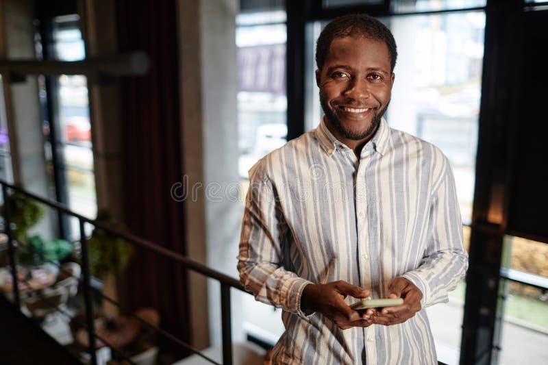 Felice giovane proprietario di un caffè o qualche altro imprenditore che ti guarda fotografie stock