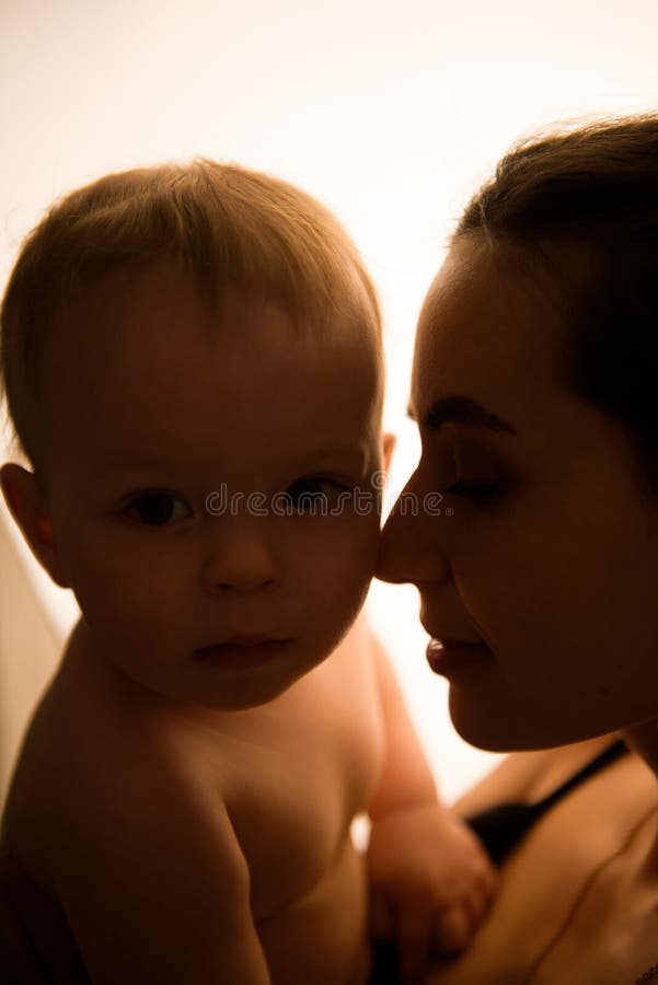 Felice madre, con il bambino che si diverte insieme sullo sfondo di una scatola luminosa. fotografia stock libera da diritti