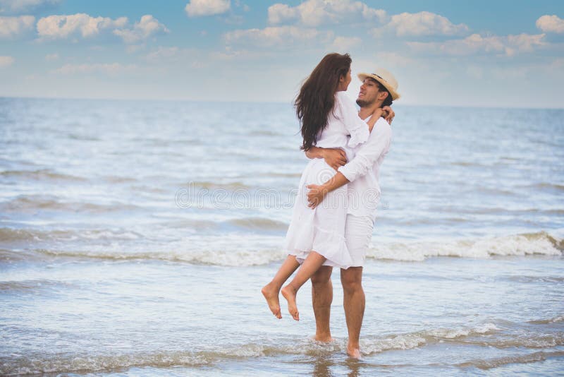 Felici coppie romantiche amate che camminano insieme sulla spiaggia fotografia stock libera da diritti