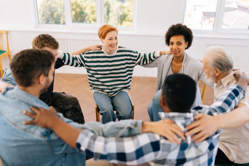Felici, multiculturali e di età diverse, gruppi di tossicodipendenti discutono di problemi e si tengono uniti ciascuno immagine stock