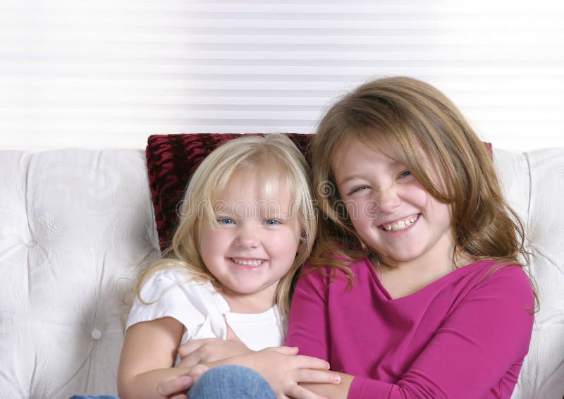 Two beautiful litlle girls on white background smiling. Two beautiful litlle girls on white background smiling