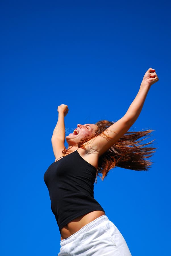 Attractive caucasian white woman model with happy laughing facial expression raising up her arms in the air outdoors. Attractive caucasian white woman model with happy laughing facial expression raising up her arms in the air outdoors