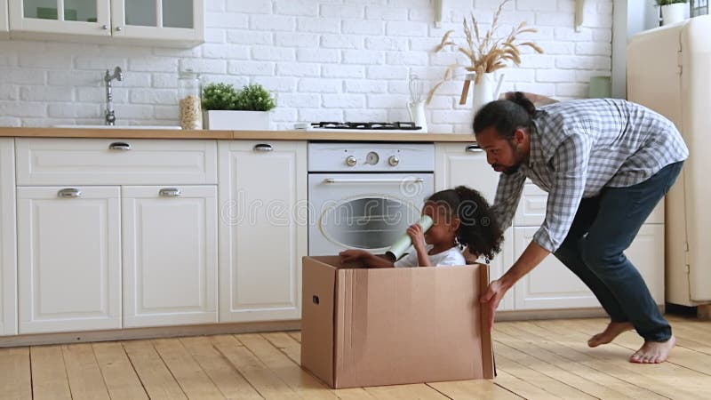 Feliz afroamericana hija niño jugando con papá en casa.