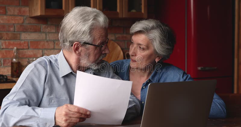 Feliz casal de meia-idade lendo documento.