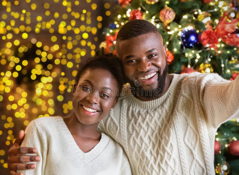 Feliz casal negro fazendo selfie com árvore de Natal ao fundo imagens de stock