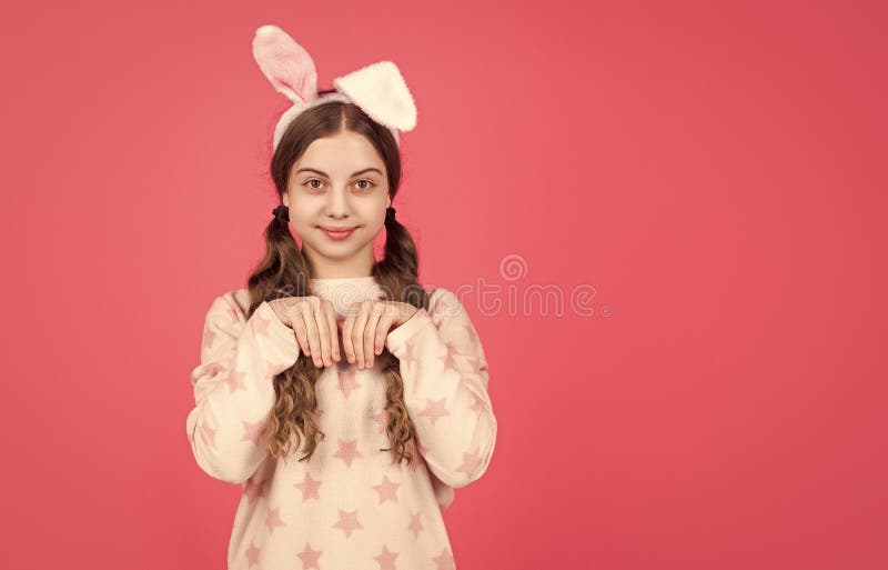 Feliz chica de Pascua en orejas de conejo y espacio de copias de pijamas en Pascua foto de archivo
