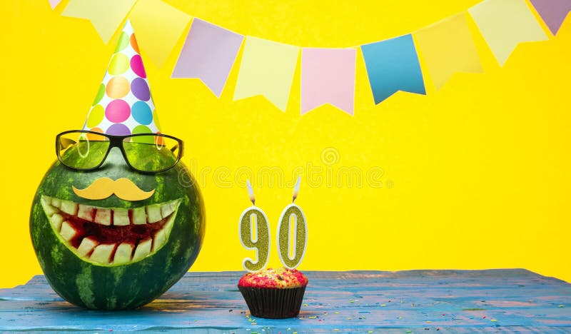 Funny watermelon in festive garlands for happy birthday greetings funny. Copy space watermelon with smile character. Happy birthday with number 90. Funny watermelon in festive garlands for happy birthday greetings funny. Copy space watermelon with smile character. Happy birthday with number 90