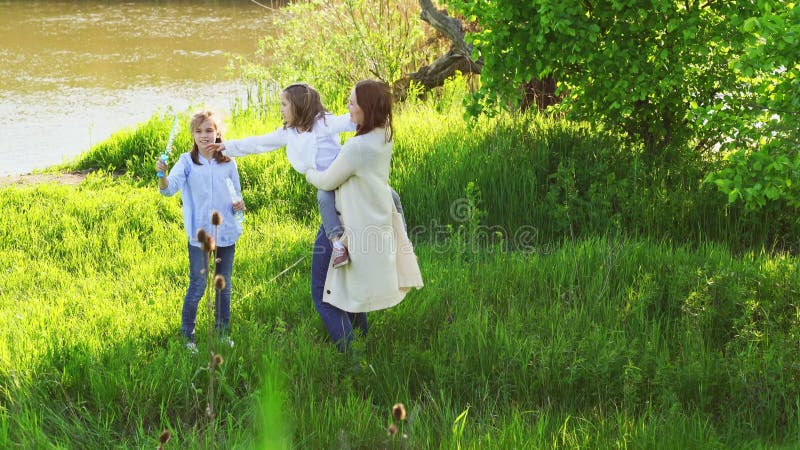 Feliz familia alegre haciendo un picnic y jugando inflar burbujas de jabón. almacen de metraje de vídeo