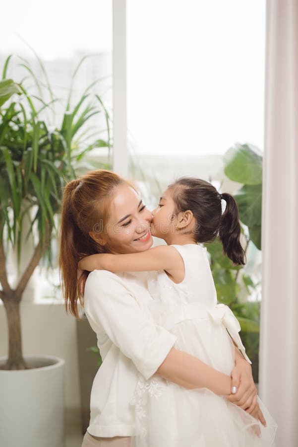 Feliz família amorosa Mãe asiática e menina criança brincando, beijando e abraçando imagens de stock Feliz família amorosa Mãe asiática e menina criança brincando, beijando e abraçando imagens de stock
