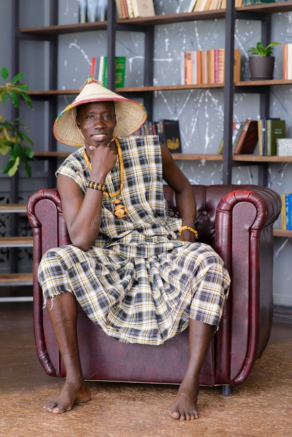 Tregua Embrión Aspirar Feliz Hombre Guapo Africano Vestido Con Ropa Tradicional Sentado En La  Silla Imagen de archivo - Imagen de estudio, bueno: 169287377