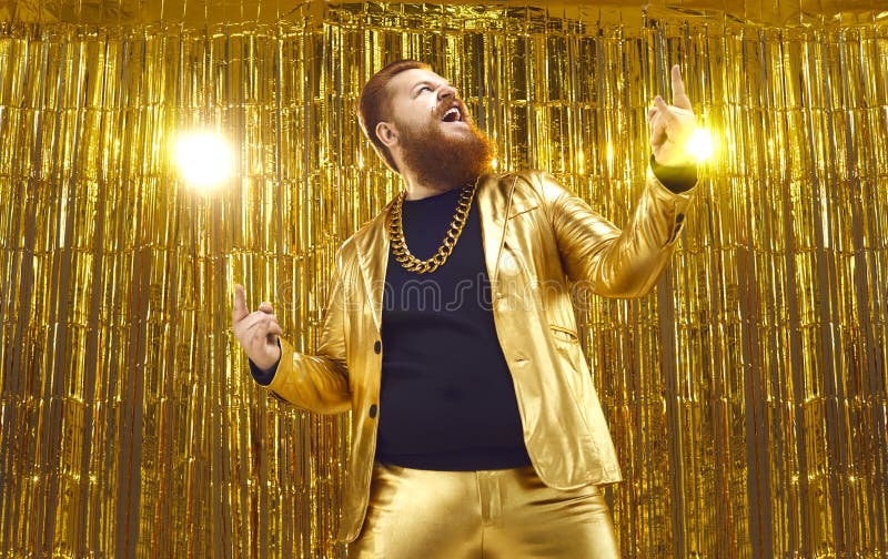Feliz hombre regordete barbudo con traje dorado brillante divertido en la fiesta de la discoteca imagen de archivo