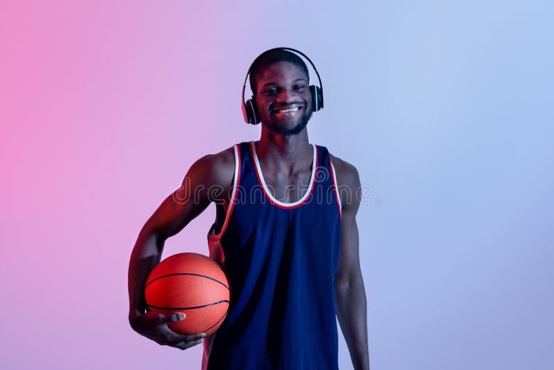 Esportivo com bola para jogar basquete, ouvindo música em fones de