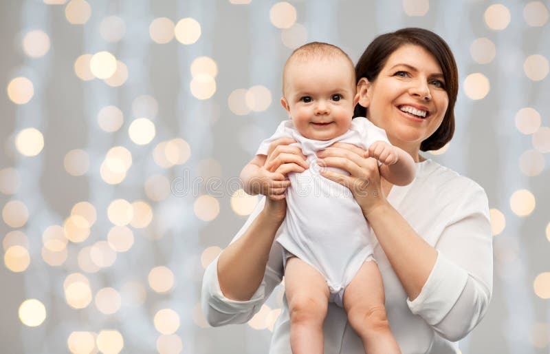 Feliz madre de mediana edad con bebés encendidos fotos de archivo libres de regalías Feliz madre de mediana edad con bebés encendidos fotos de archivo libres de regalías