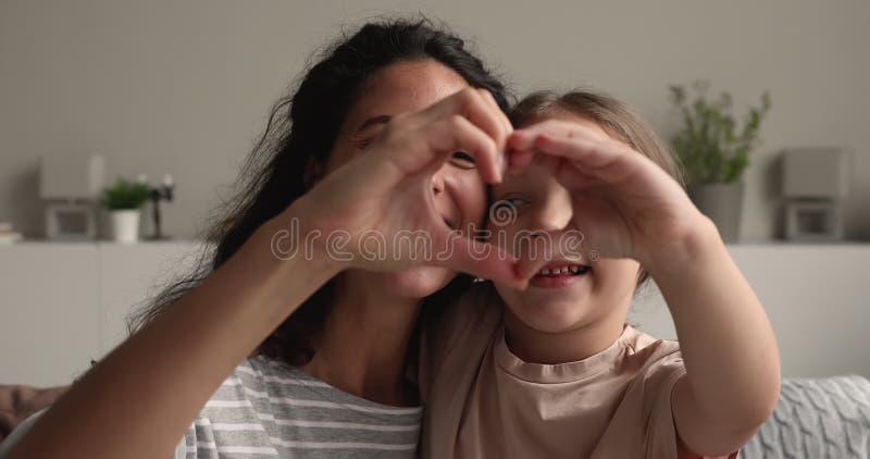 Feliz madre joven haciendo amor signo con sonriente hijita. metrajes