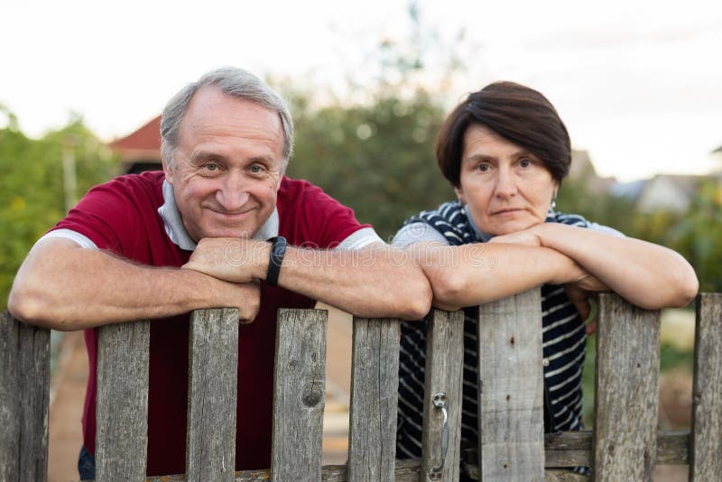 Feliz matrimonio de pareja de ancianos tiene conversación cerca de la valla de su granja fotografía de archivo libre de regalías