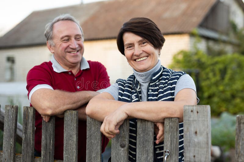 Feliz matrimonio de pareja de ancianos tiene conversación cerca de la valla de su granja foto de archivo libre de regalías