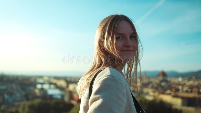Feliz mujer caucásica mirando hacia atrás mientras camina por florencia vista de la ciudad vieja. bella joven disfrutando de sus v almacen de video