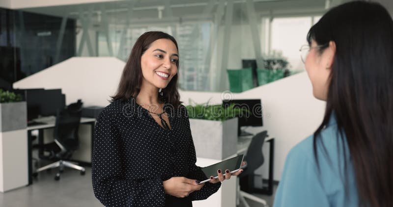 Feliz mujer de negocios de Medio Oriente dándole la mano a colega asiática metrajes