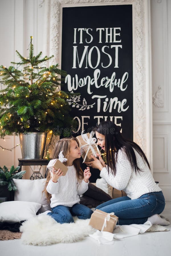 Feliz Natal e boas festas Mamã alegre e sua menina bonito da filha que abrem um presente de Natal Pai e fotografia de stock royalty free Feliz Natal e boas festas Mamã alegre e sua menina bonito da filha que abrem um presente de Natal Pai e fotografia de stock royalty free