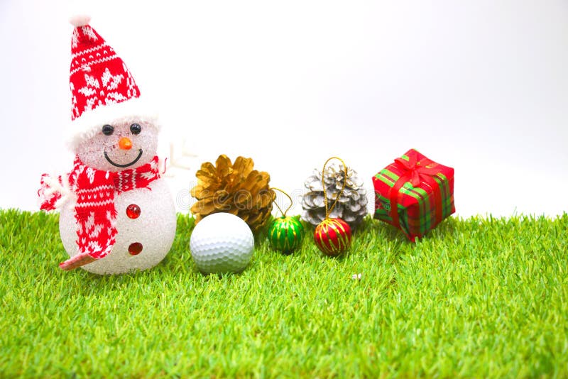Snowman and one golf ball with Christmas ornament on green grass. Snowman and one golf ball with Christmas ornament on green grass