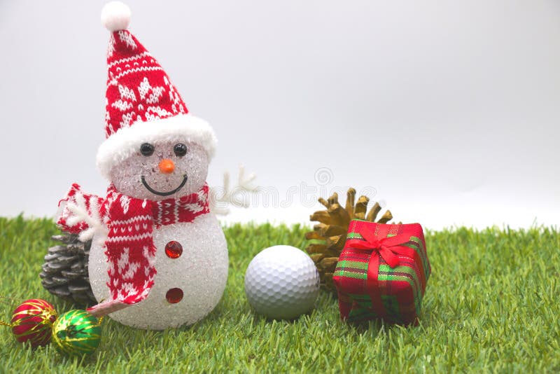 Snowman and one golf ball with Christmas ornament on green grass. Snowman and one golf ball with Christmas ornament on green grass