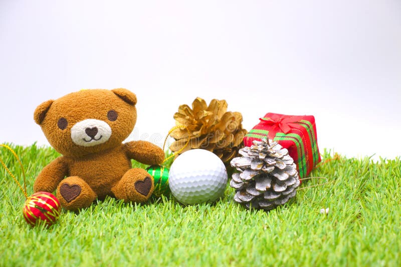 Bear and one golf ball with Christmas tree on green grass. Bear and one golf ball with Christmas tree on green grass