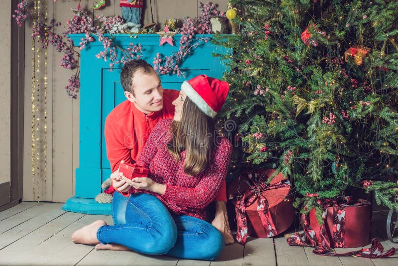Feliz Navidad Pares jovenes que celebran la Navidad en casa imágenes de archivo libres de regalías Feliz Navidad Pares jovenes que celebran la Navidad en casa imágenes de archivo libres de regalías