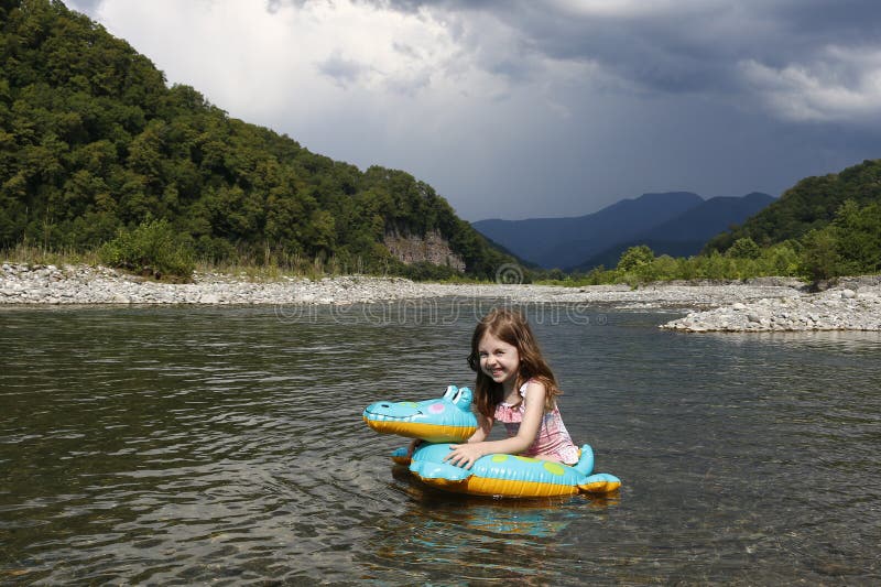 Feliz niña risible disfrutando nadando en el río con cocodrilo de anillo de goma. vacaciones de verano activas en la playa fotos de archivo libres de regalías