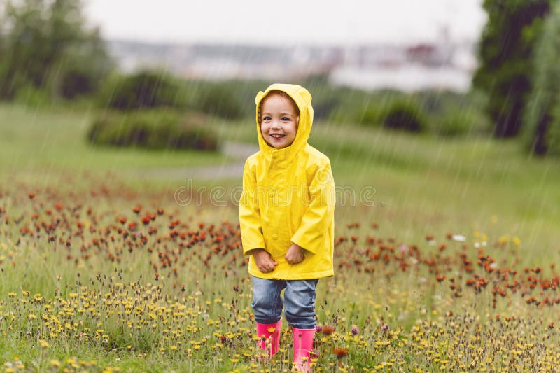 Feliz niño gracioso con paraguas multicolor bajo el día de lluvia de verano foto de archivo libre de regalías