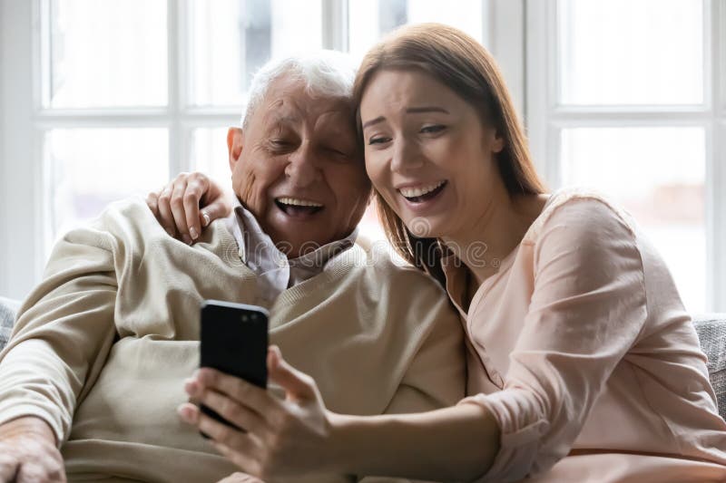 Feliz padre mayor e hija adulta se toman selfie en el teléfono celular fotografía de archivo