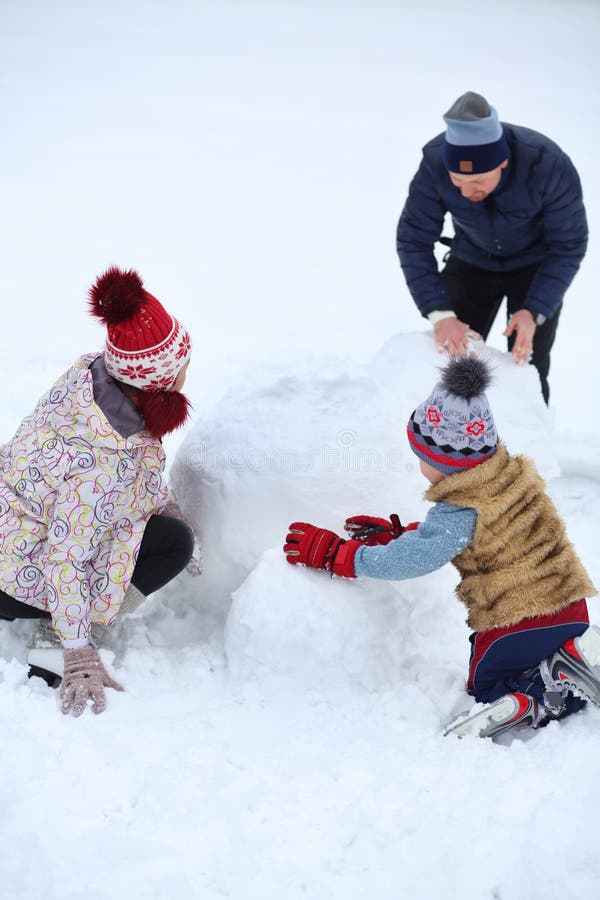 Feliz pai e filho pequeno fazem boneco de neve fotos de stock