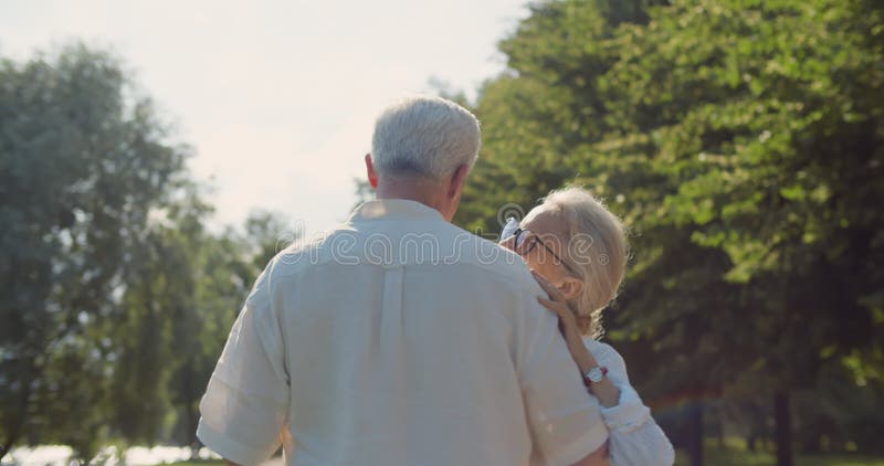 Feliz pareja de ancianos bailando en el parque de verano