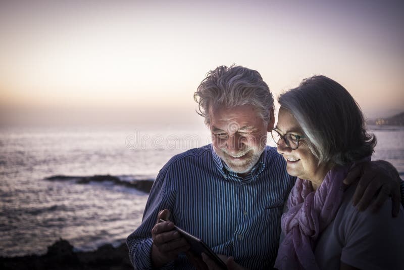 Feliz Pareja De Jubilados Divirtiéndose Sentados En Los Acantilados, Luz Del Anochecer Mirando La Misma Tableta Concepto De Retir Imagen de archivo - Imagen de alegre, pares: 198714145 Feliz Pareja De Jubilados Divirtiéndose Sentados En Los Acantilados, Luz Del Anochecer Mirando La Misma Tableta Concepto De Retir Imagen de archivo - Imagen de alegre, pares: 198714145