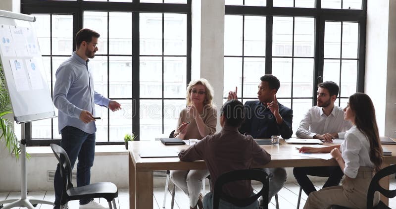 Feliz y diverso empleados escuchando a un profesor motivado en la formación.