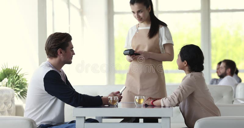 Feliz y diverso par de clientes saliendo en café