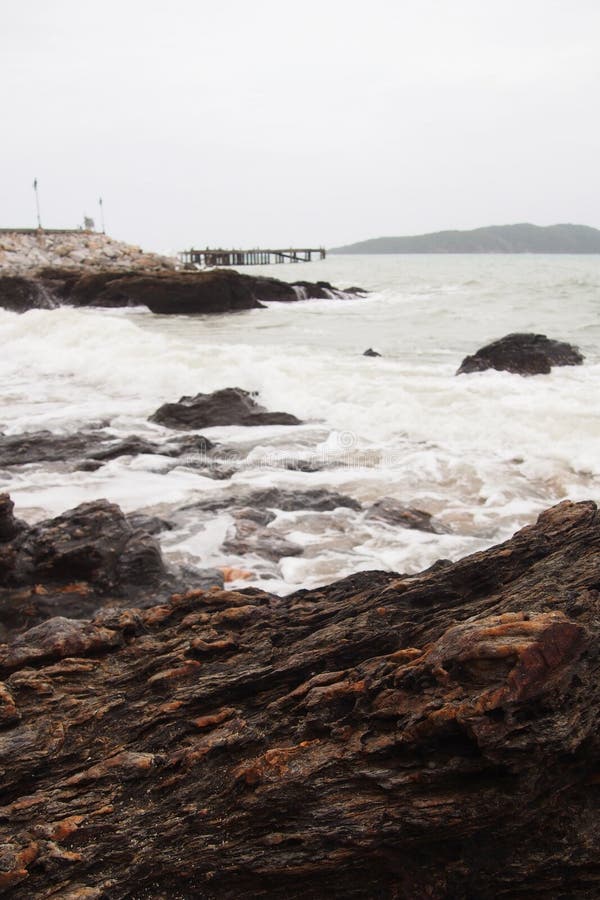 Felsen auf dem Strand durch das Meer, wenn die Brücken in das Meer und in die Laternen ausdehnen, auf einem natürlichen Hintergru lizenzfreie stockbilder Felsen auf dem Strand durch das Meer, wenn die Brücken in das Meer und in die Laternen ausdehnen, auf einem natürlichen Hintergru lizenzfreie stockbilder