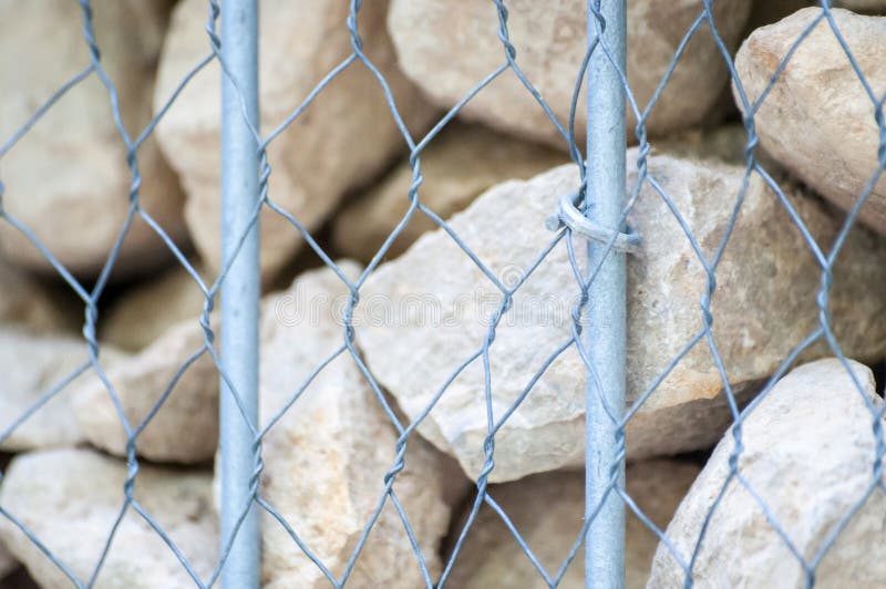 Felsige Wand hergestellt mit Felsen, dem Fechten und Metallkiste lizenzfreie stockbilder Felsige Wand hergestellt mit Felsen, dem Fechten und Metallkiste lizenzfreie stockbilder