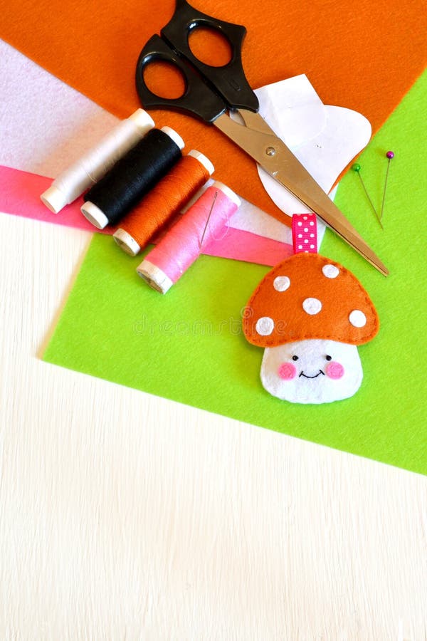 Felt mushroom, thread, needle, paper templates, pins, scissors stock photo Felt mushroom, thread, needle, paper templates, pins, scissors stock photo