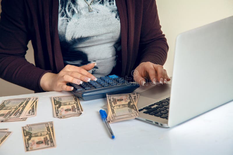Female accountant on a calculator counts money