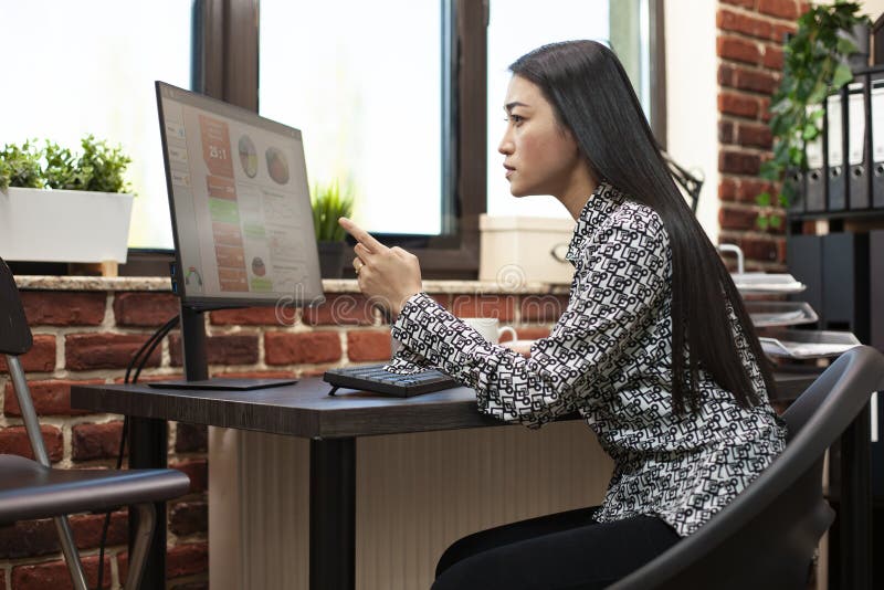 Female analyst points at computer screen royalty free stock image